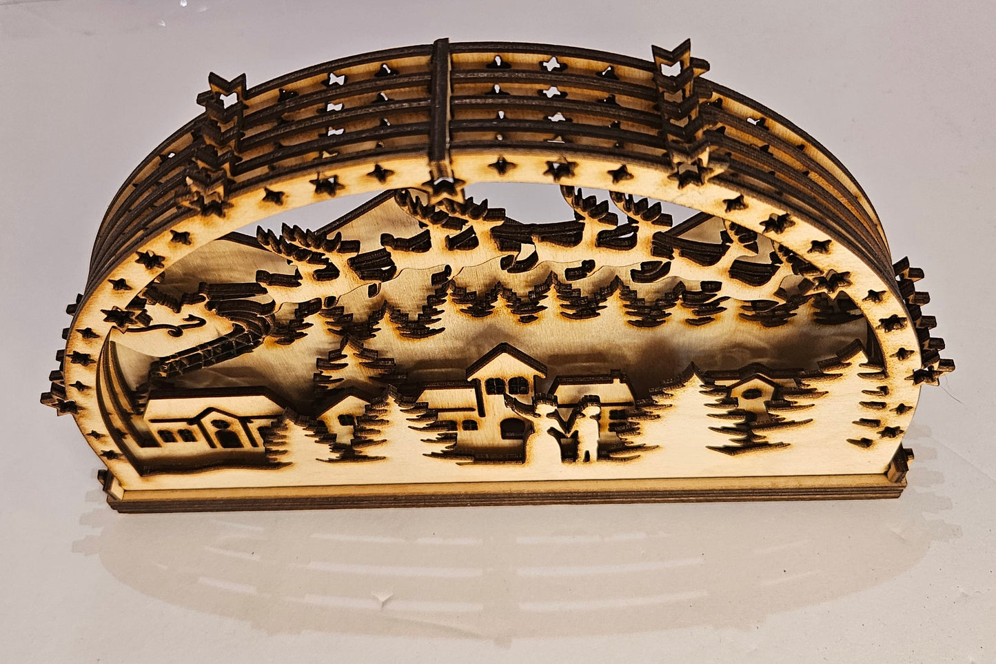 Wooden landscape model with trees and buildings on a white background